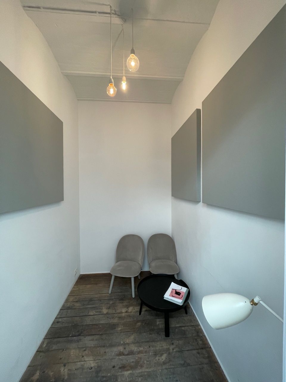 Panneaux muraux acoustiques gris dans un lounge étroit à l'éclairage design