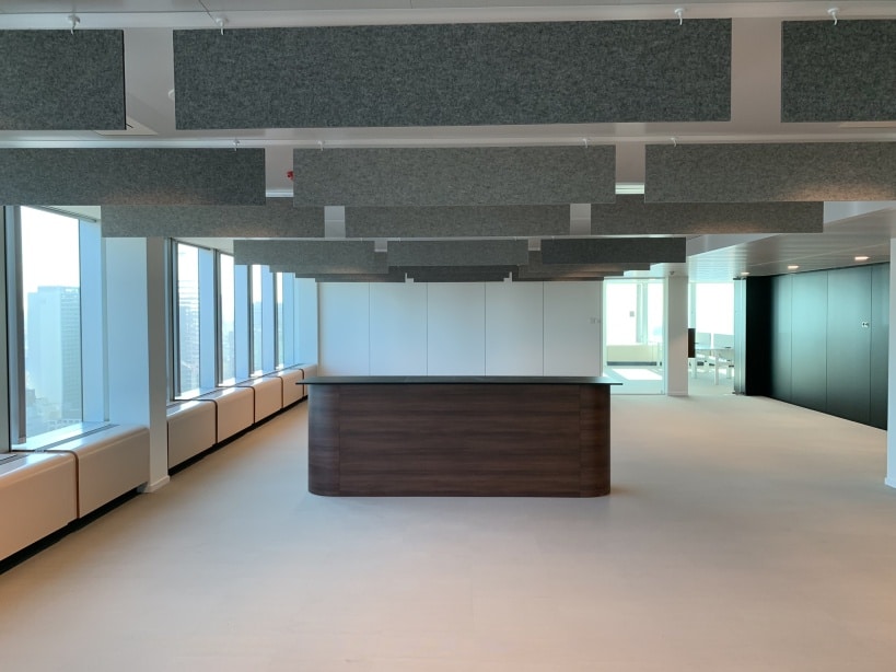 Motif géométrique de baffles de plafond gris au-dessus d'un comptoir d'accueil