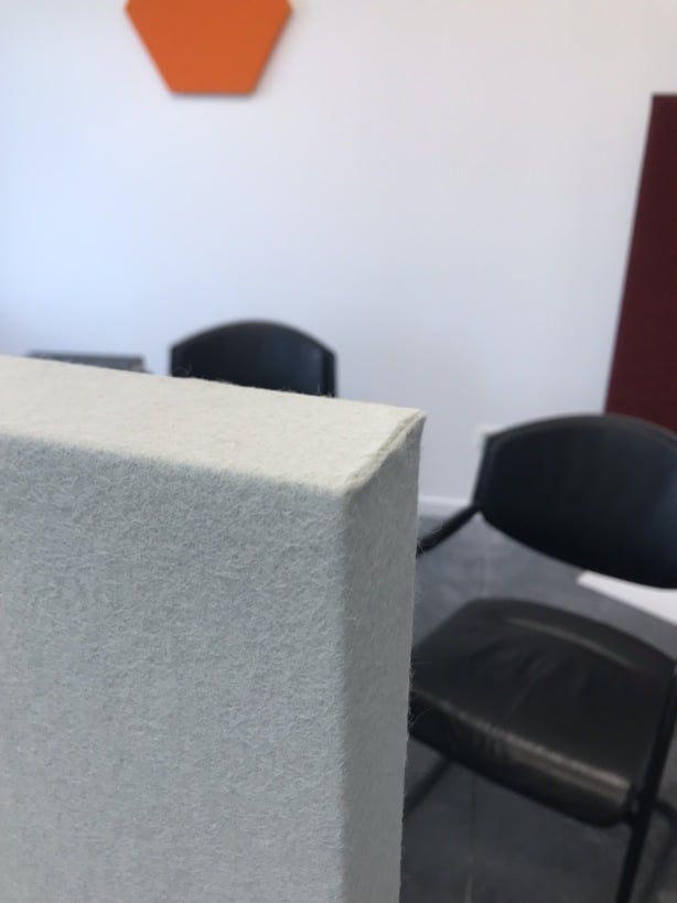Gros plan du bord d'un panneau acoustique blanc en salle de réunion