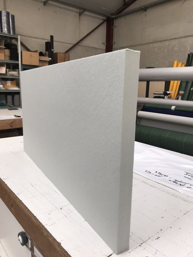 Baffle acoustique blanc posé sur table de travail en atelier