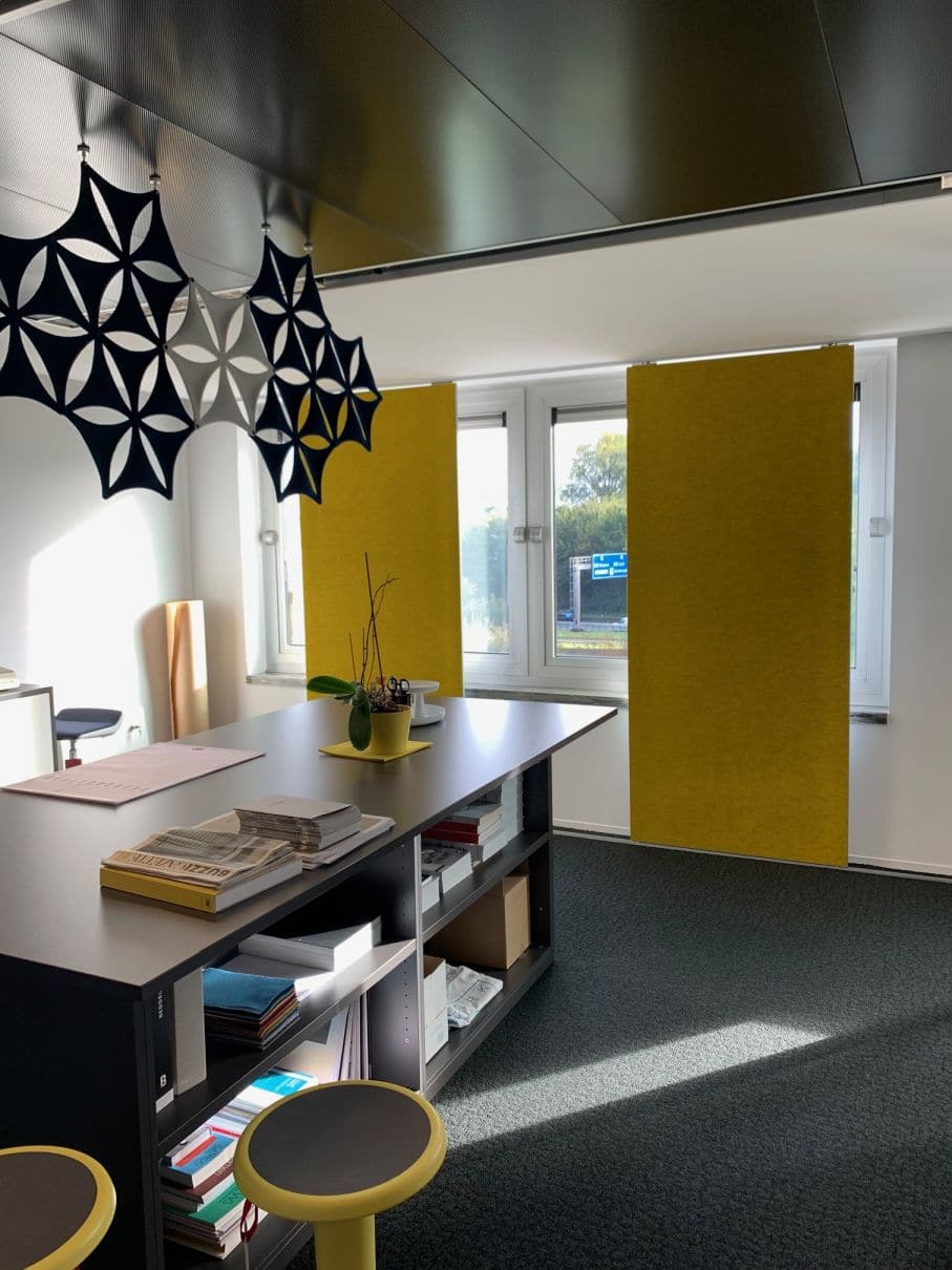 Panneaux rideaux acoustiques jaune ocre devant les fenêtres d'un bureau