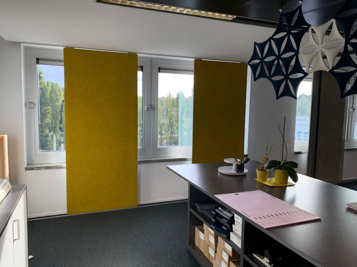Panneaux acoustiques jaunes devant fenêtre avec baffles de plafond design