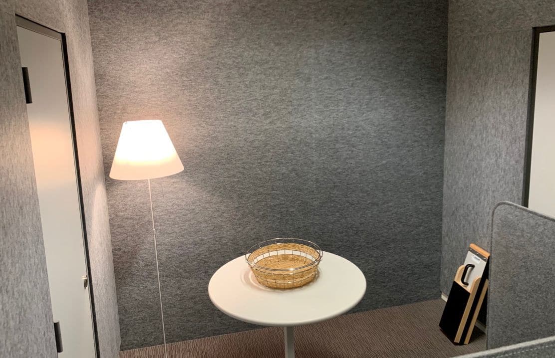 Panneaux muraux acoustiques gris dans un lounge avec lampe de table