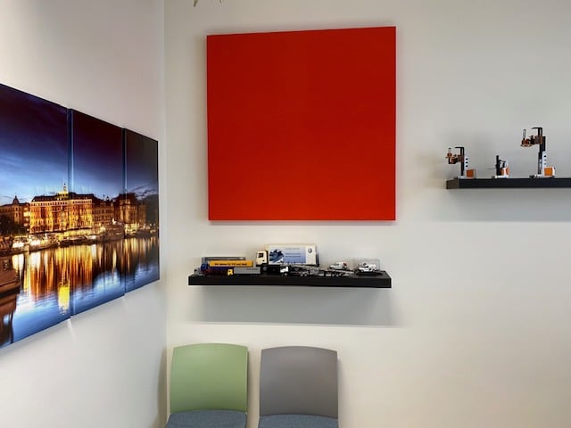 Panneau acoustique carré rouge dans un showroom de maquettisme