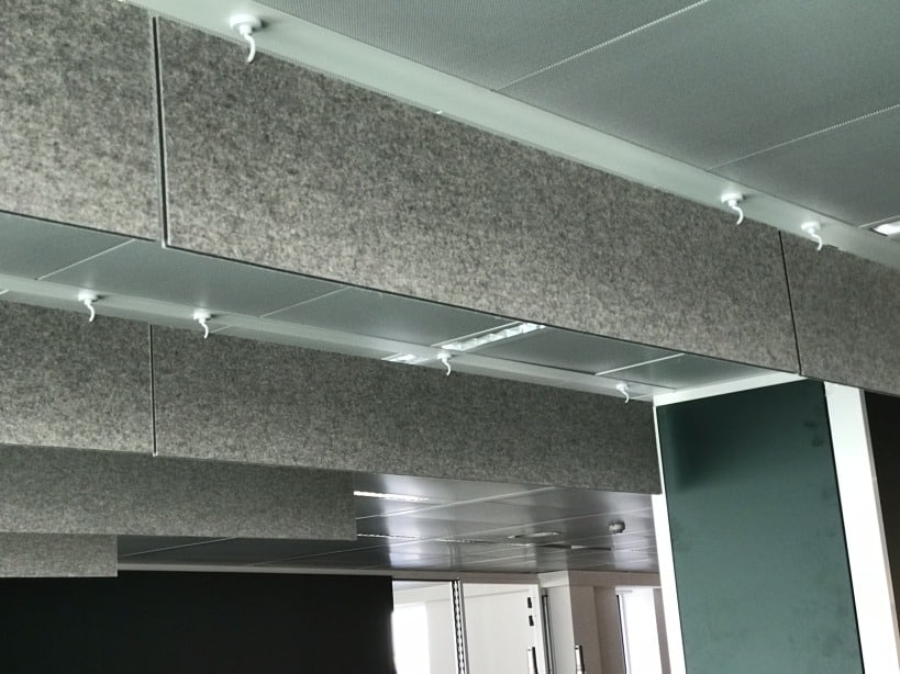 Rangée de baffles acoustiques gris suspendus au plafond d'un bureau
