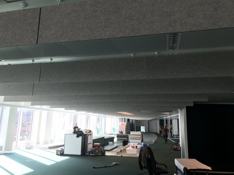 Grande installation de baffles gris dans un bureau ouvert pendant la pose