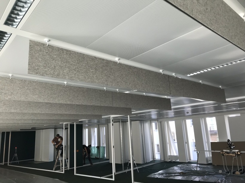 Baffles acoustiques au-dessus de postes de travail dans un bureau moderne en construction