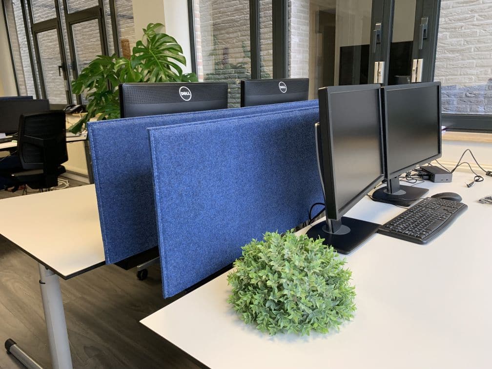 Cloisons acoustiques bleu foncé sur bureaux blancs avec plantes
