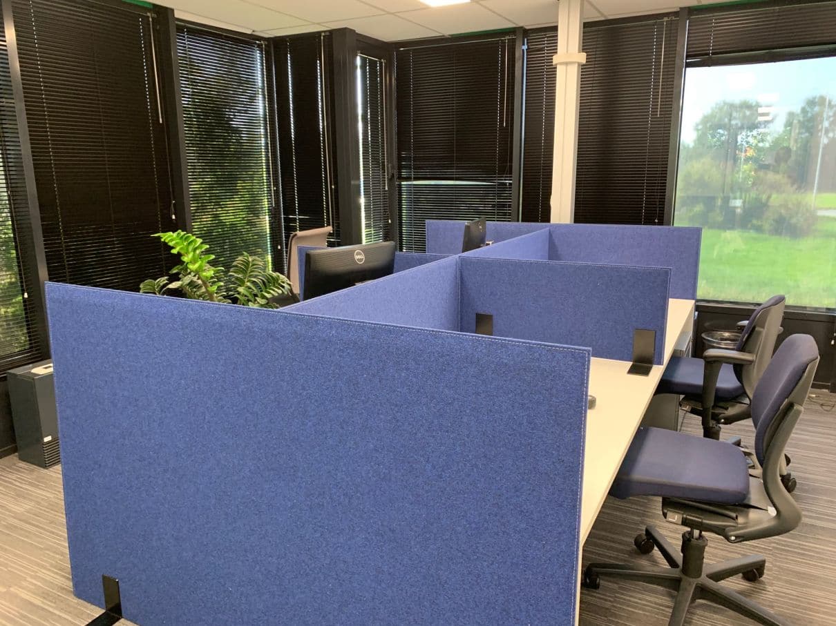 Hautes cloisons acoustiques bleues autour de postes de travail