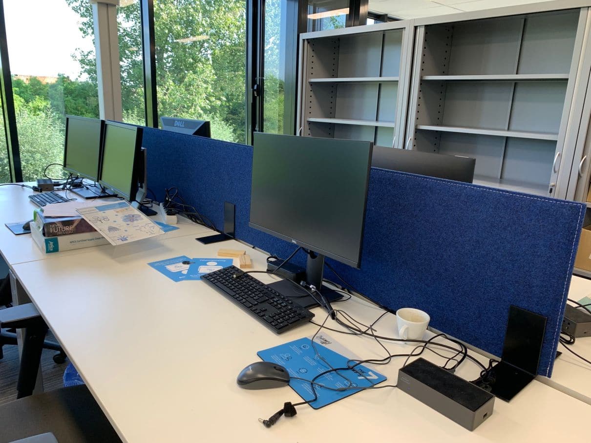 Écran de bureau acoustique bleu foncé entre postes à double écran