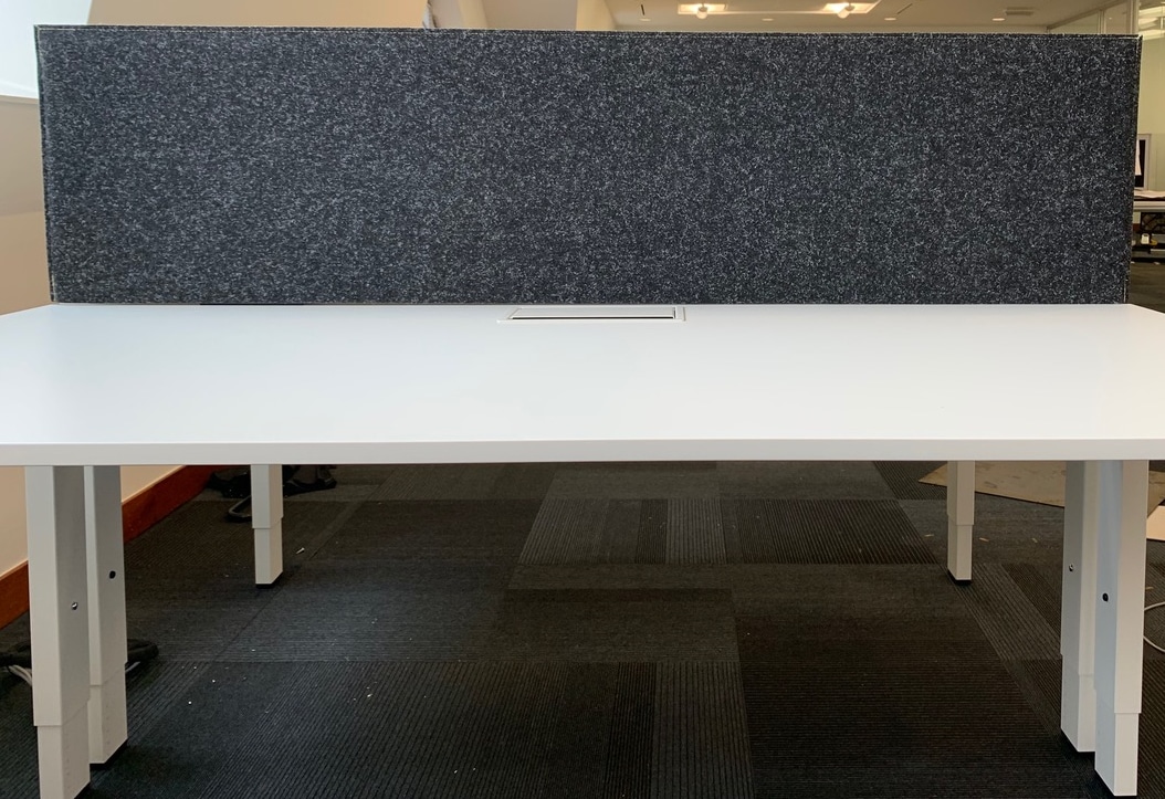 Écran de bureau en feutre gris foncé sur bureau blanc en open space