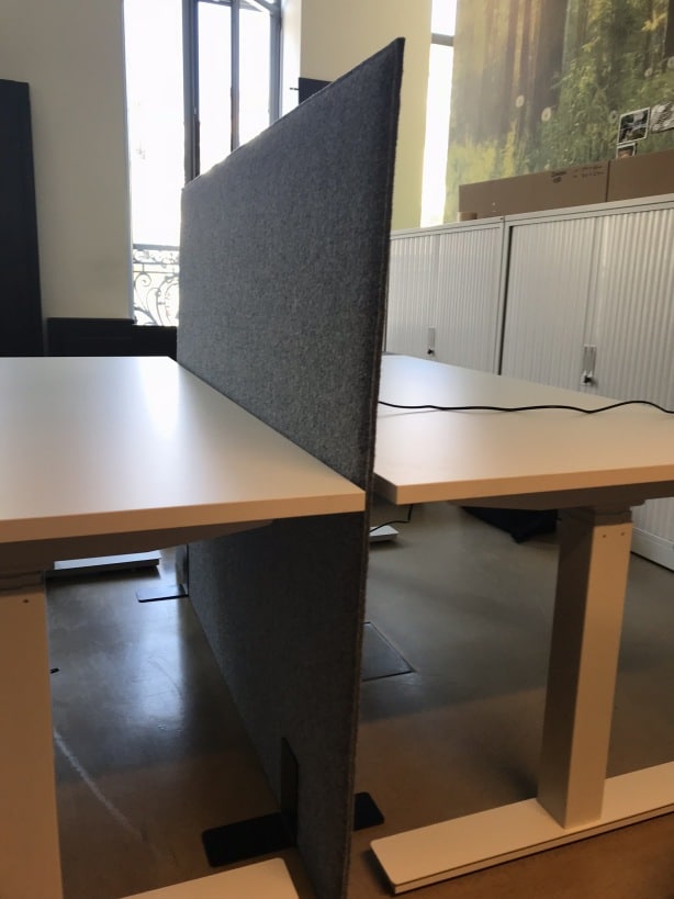 Cloison acoustique grise entre deux bureaux assis-debout