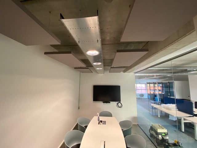 Îlots acoustiques foncés sous plafond béton dans une meeting room