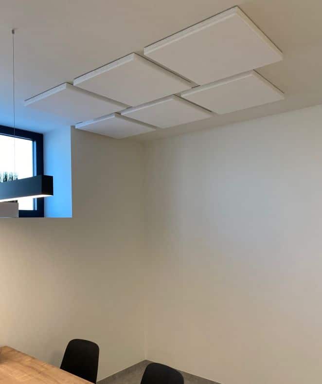 Îlots de plafond acoustiques blancs rectangulaires au-dessus d'une table de réunion