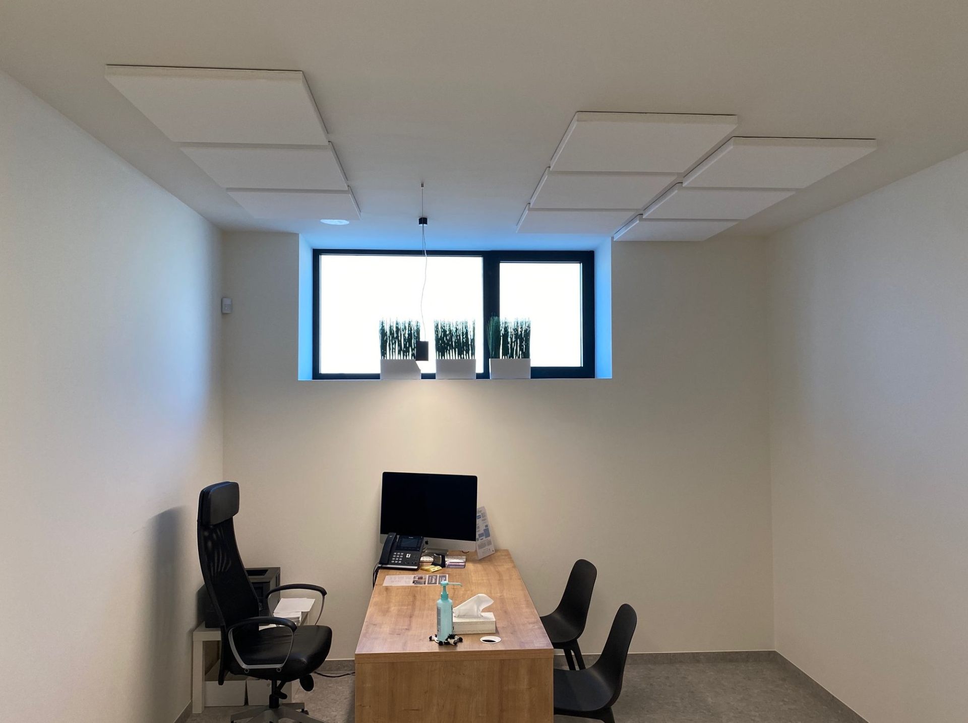 Îlots de plafond acoustiques blancs dans un bureau privé avec bureau en bois
