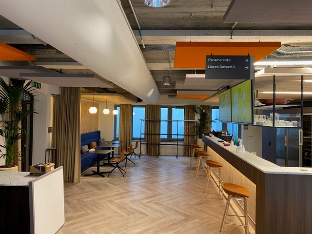 Îlots de plafond acoustiques orange et blancs dans un lounge de coworking