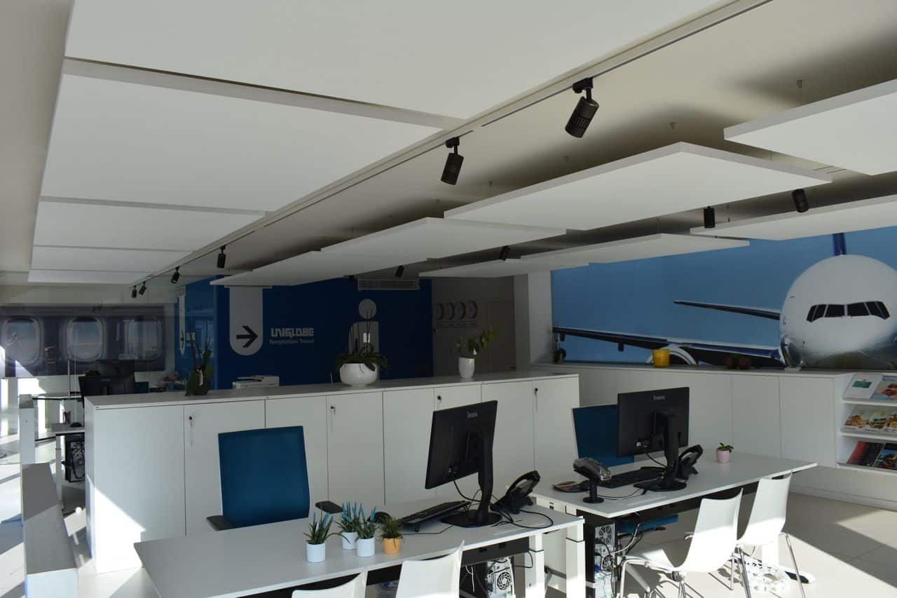 Îlots de plafond acoustiques blancs dans le grand bureau d'une agence de voyage