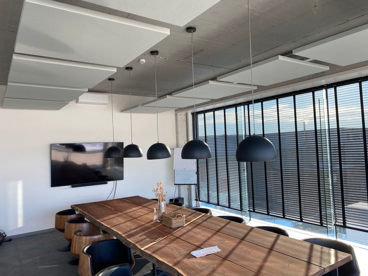 Îlots de plafond acoustiques blancs dans une salle de réunion avec grande baie vitrée