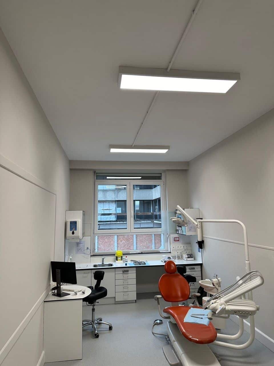 Plafond acoustique dans un cabinet dentaire avec fauteuil de soins rouge