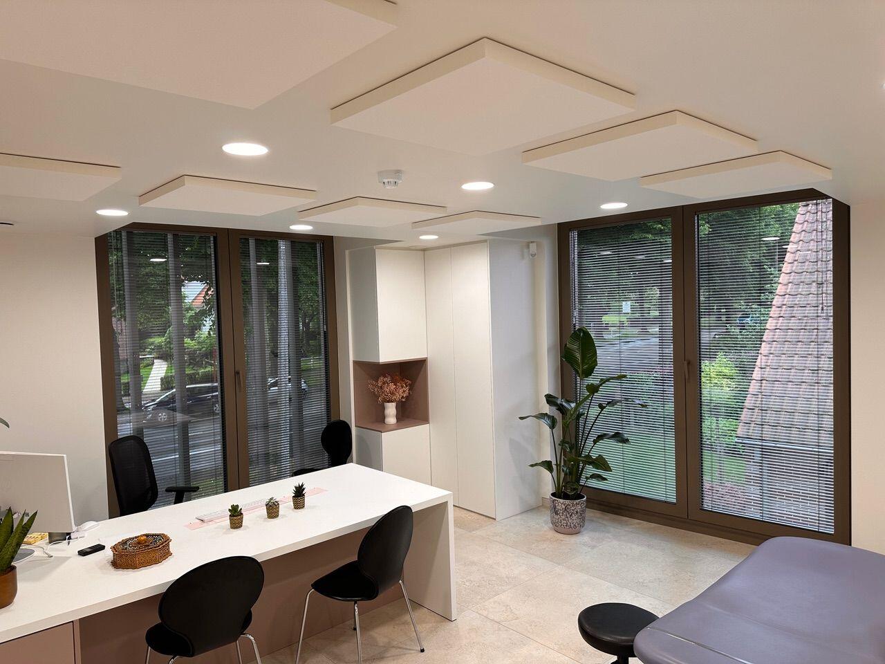 Panneaux de plafond acoustiques dans un cabinet médical moderne aux grandes baies vitrées