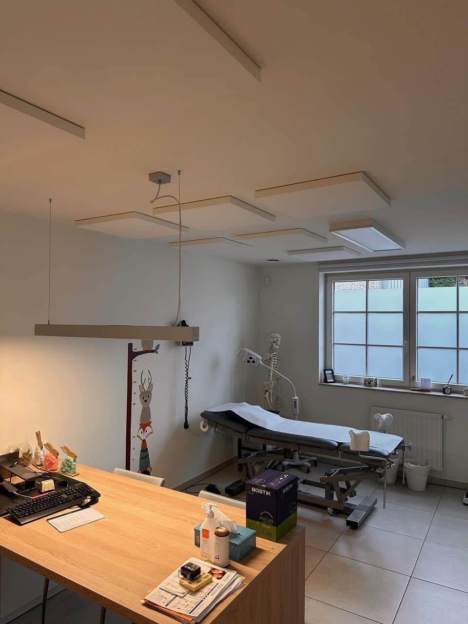 Panneaux de plafond acoustiques blancs dans une salle de consultation de médecin généraliste