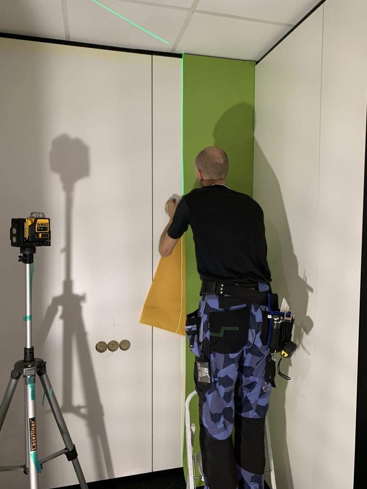 Pose d'un habillage mural acoustique par un technicien