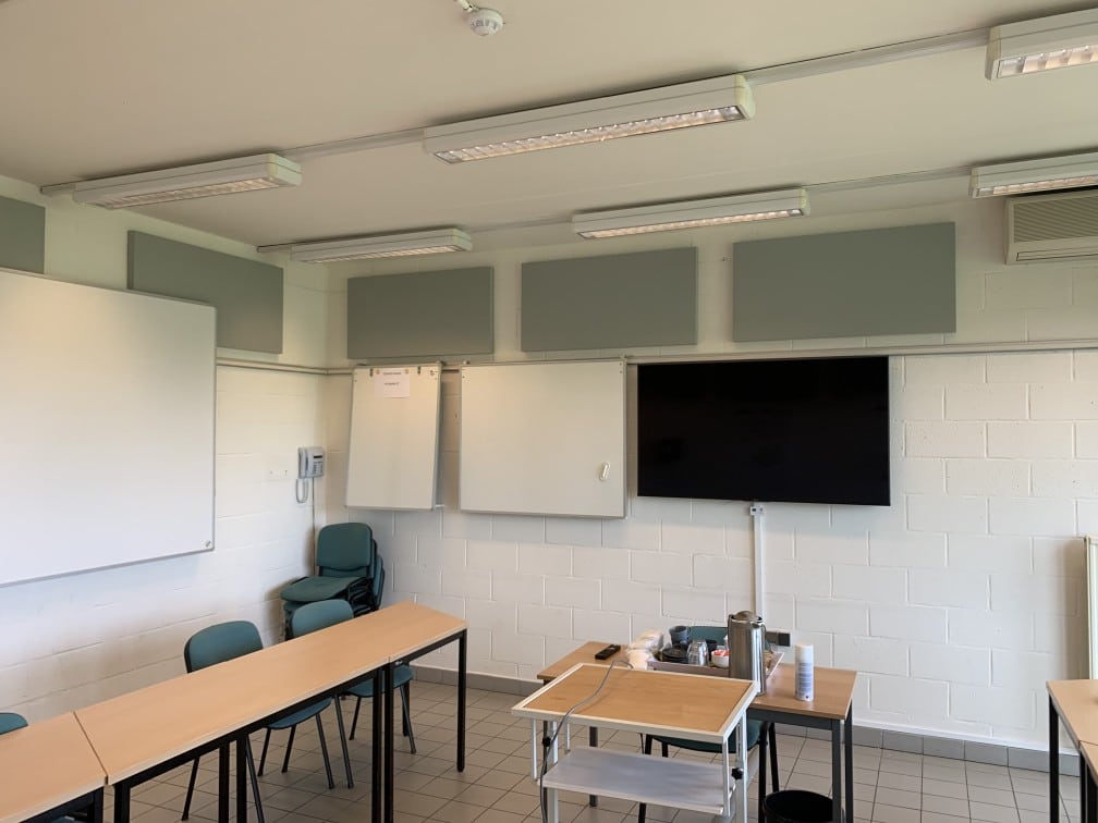 Panneaux acoustiques verts au plafond et au mur dans une salle de classe