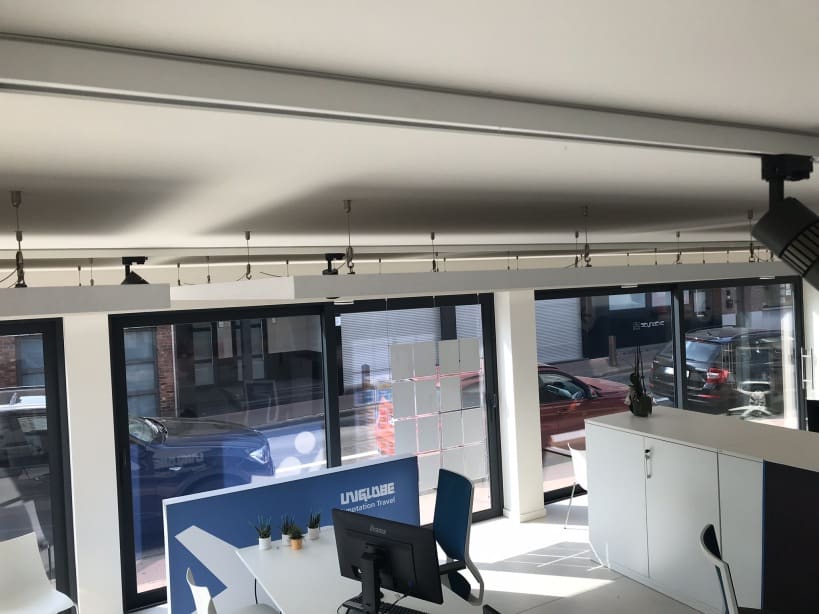 Rails de suspension pour panneaux acoustiques devant une grande baie