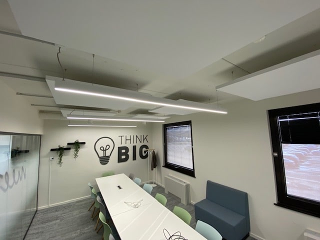 Baffles de plafond au-dessus d'une table de réunion avec mur THINK BIG