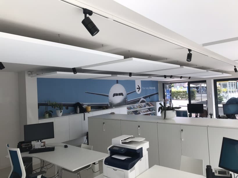 Îlots acoustiques blancs au-dessus de bureaux avec mur photo