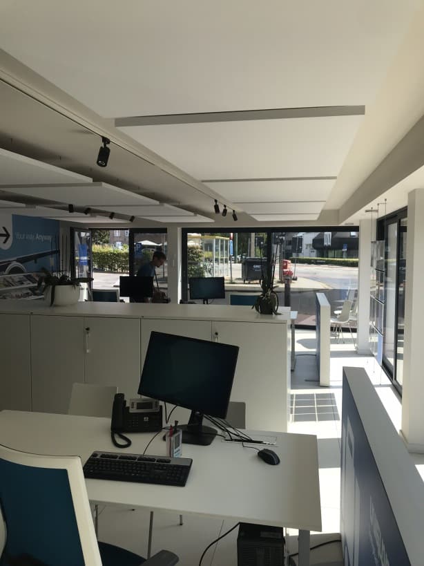 Panneaux de plafond acoustiques au-dessus d'un poste de travail ouvert
