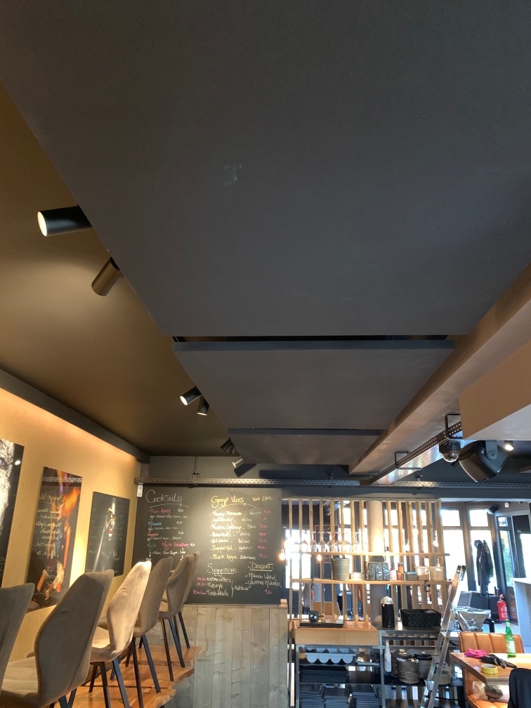 Îlots acoustiques foncés dans un établissement horeca à l'éclairage d'ambiance