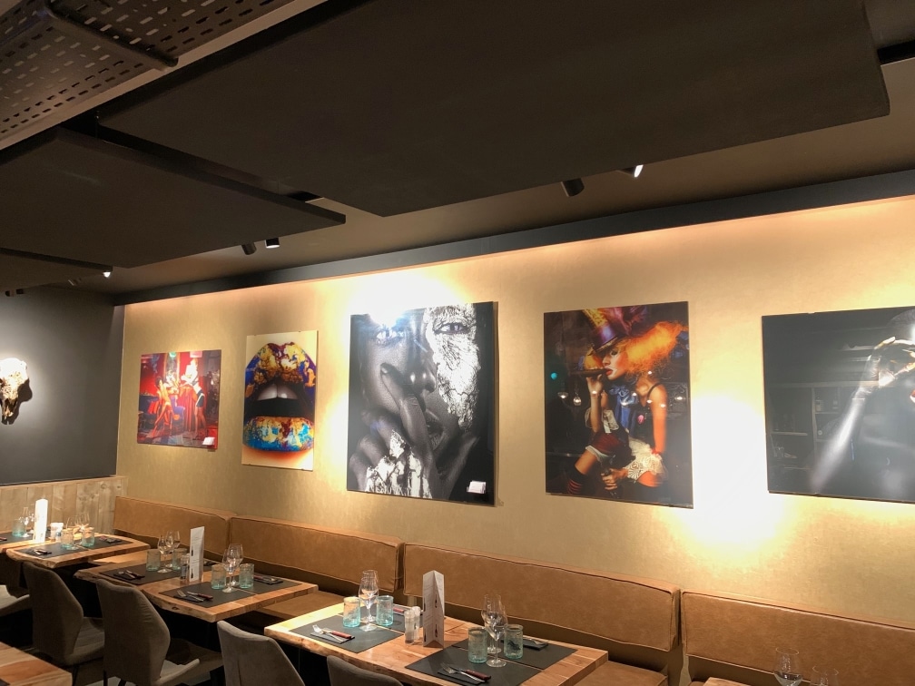 Correction acoustique au-dessus d'une banquette avec grandes œuvres d'art