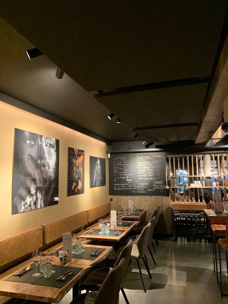 Îlot acoustique au-dessus d'une banquette dans un restaurant chaleureux