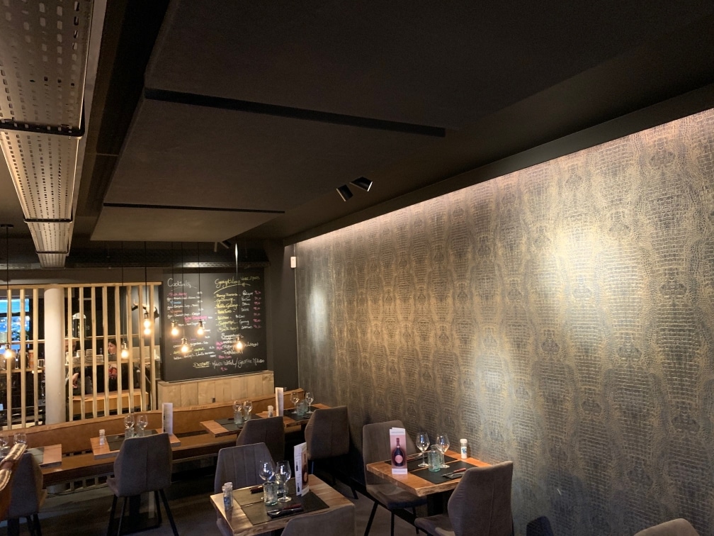 Îlot acoustique foncé au-dessus de tables avec mur tapissé