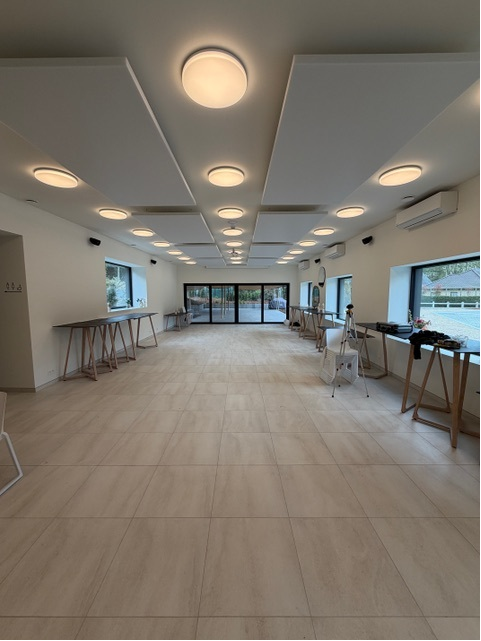Îlots de plafond acoustiques blancs carrés dans une salle polyvalente lumineuse