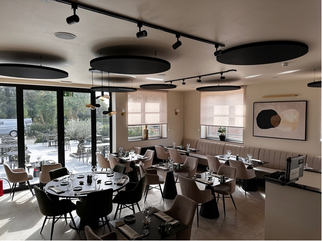 Îlots de plafond acoustiques ronds noirs au-dessus de la salle à manger d'un restaurant moderne